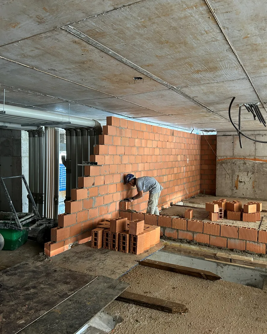 Colaborador assentando blocos cerâmicos em pavimento tipo