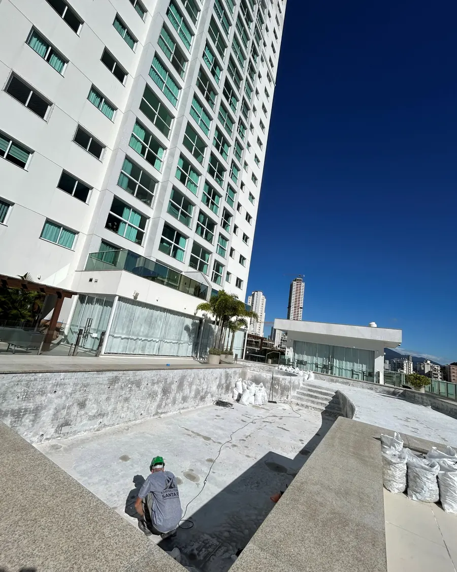 Colaborador na manutenção do piso da área de lazer de um edifício entregue